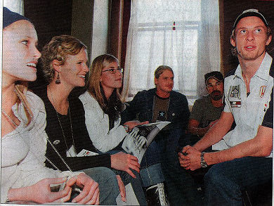 Die Formule Een-renjaer, Jenson Button (regs) gesels met 'n groep jongmense.  Heel links is Aimee Henning